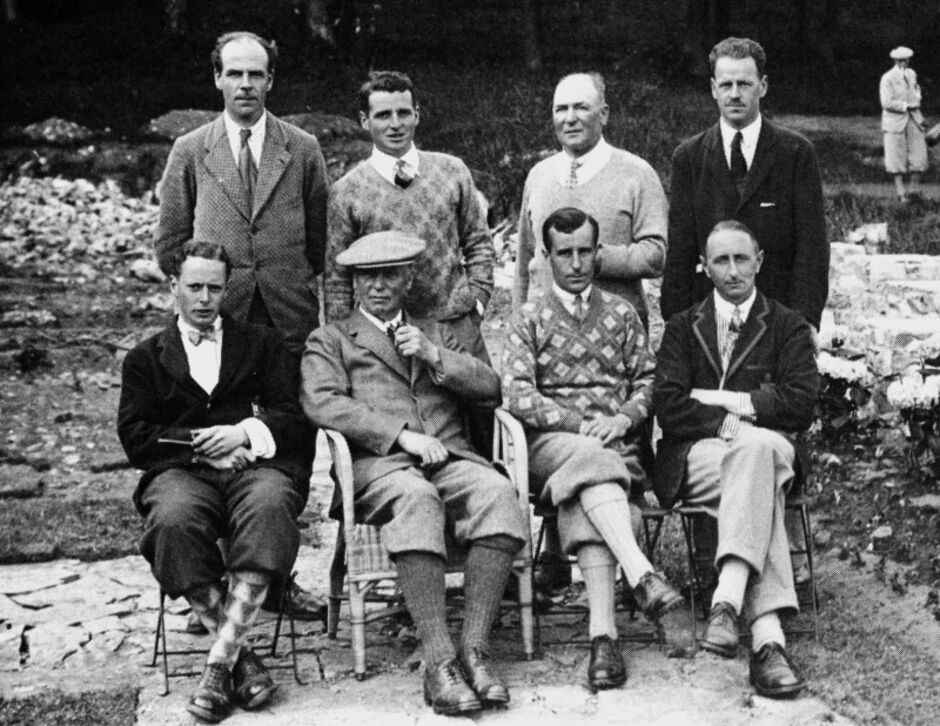 Black and white group photograph of the 1927 Golf Club of Dublin Senior Cup team, showing eight men posed in two rows outdoors, four seated in front and four standing behind, dressed in period golf attire including argyle sweaters, suits, and plus-fours